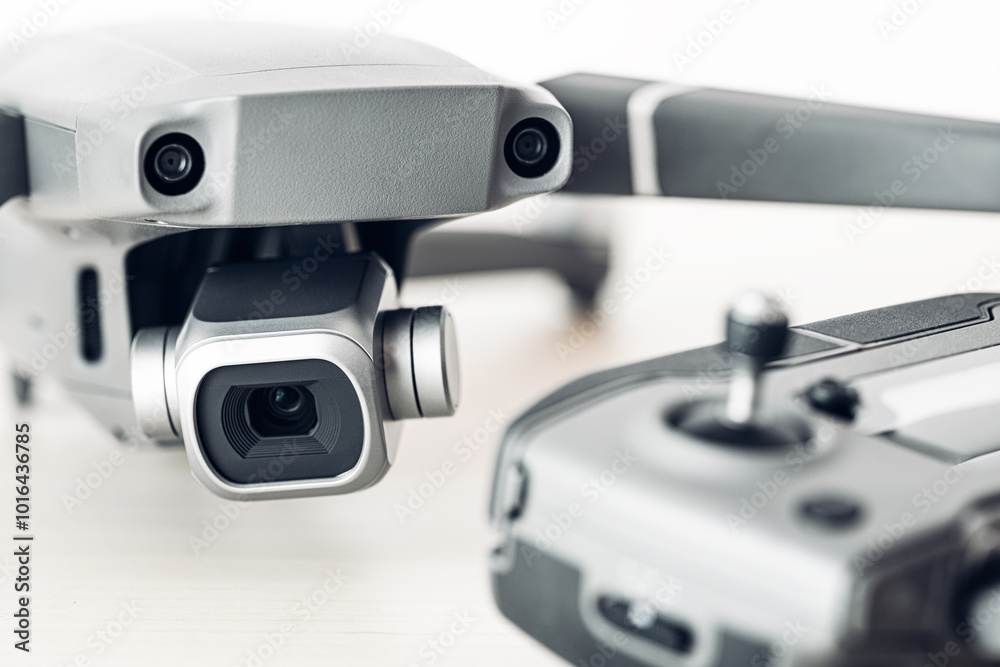 Camera on pro drone body with remote controller out of focus in the background Camera on pro drone body with remote controller out of focus in the background