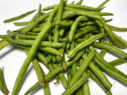 A vibrant pile of fresh green beans, just plucked from the garden, ready to add a burst of flavor isolated on white photo