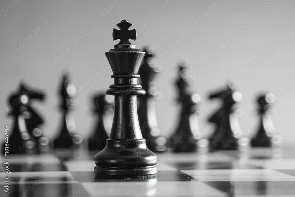 Beautiful chess piece standing on checkered game board during strategic game of chess Beautiful chess piece standing on checkered game board during strategic game of chess