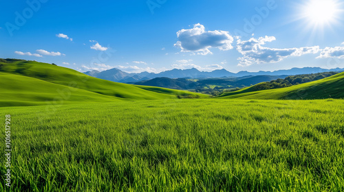 Lush green hills stretch under bright blue sky, with mountains in distance. vibrant landscape evokes sense of tranquility and natural beauty. 