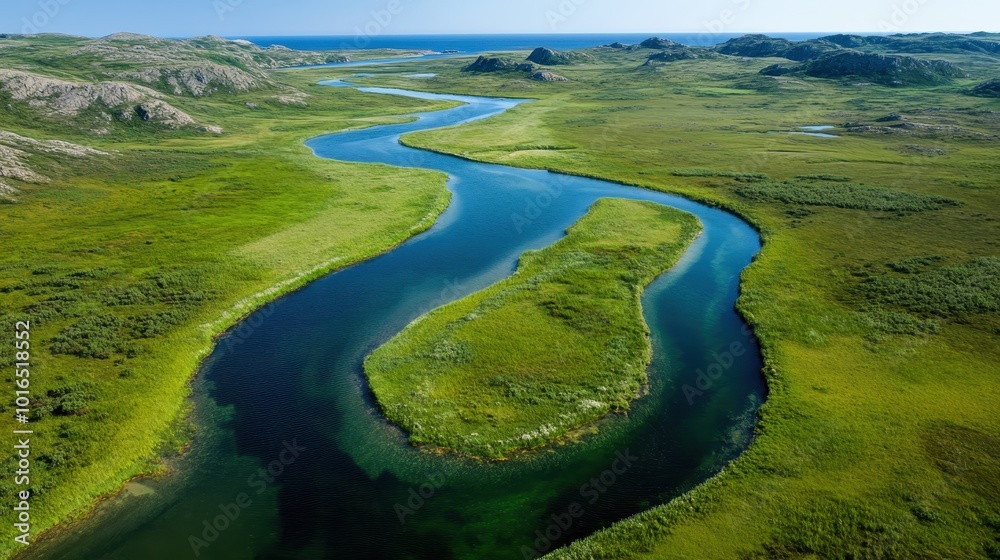 A serpentine river cuts through vast green fields and rocky terrain, leading toward the horizon, with a sea view in the background under a clear sky, an exploration of nature.