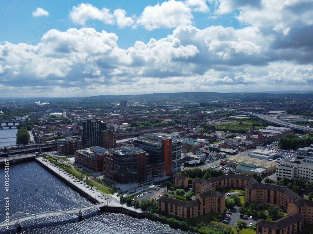 Fototapeta premium Aerial View of Buildings at Central Glasgow city of Scotland From River Clyde, Great Britain. Drone's camera Footage Was Captured on June 5th, 2024 from Medium High Altitude.