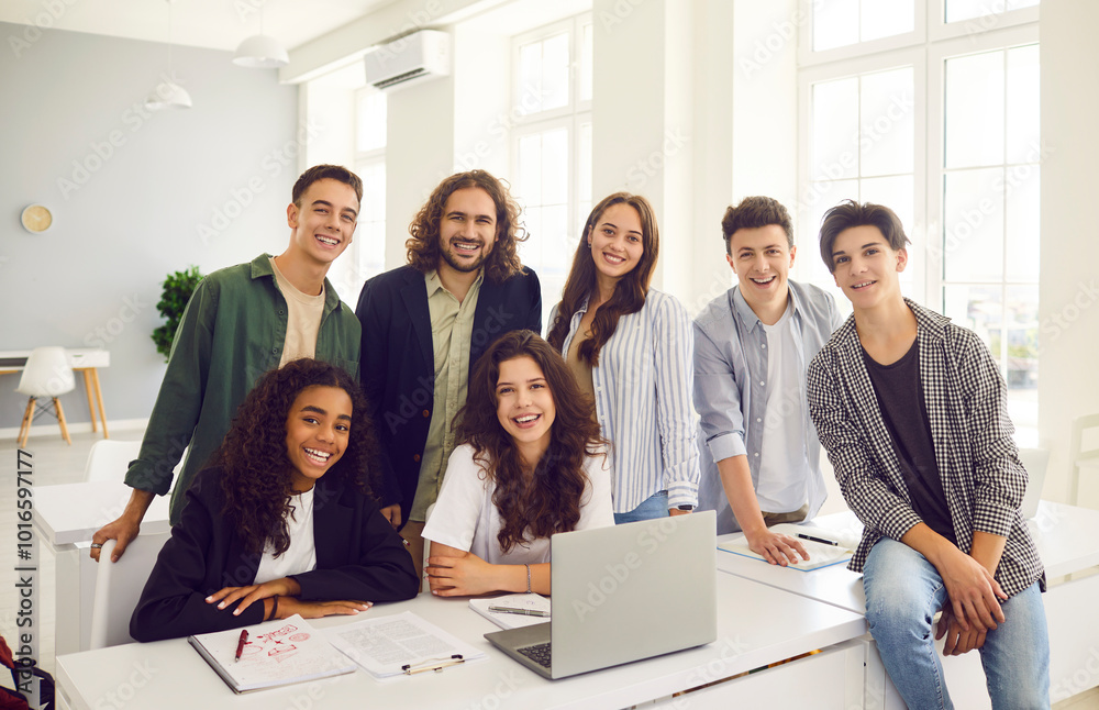 Portrait of a diverse group of happy multinational teenage students during lesson with teacher in a school classroom. Learning reflecting the positive interaction between the students and teacher. Portrait of a diverse group of happy multinational teenage students during lesson with teacher in a school classroom. Learning reflecting the positive interaction between the students and teacher.