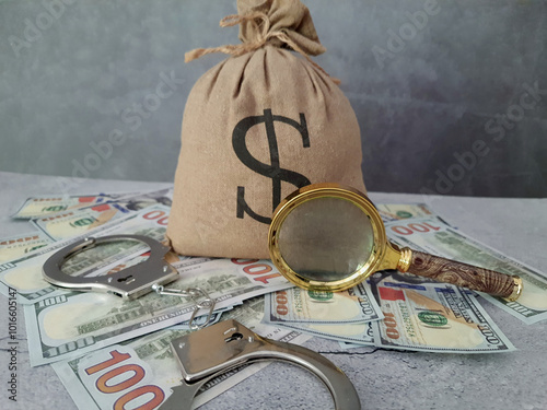 Bag of money, magnifying glass, and handcuffs. photo