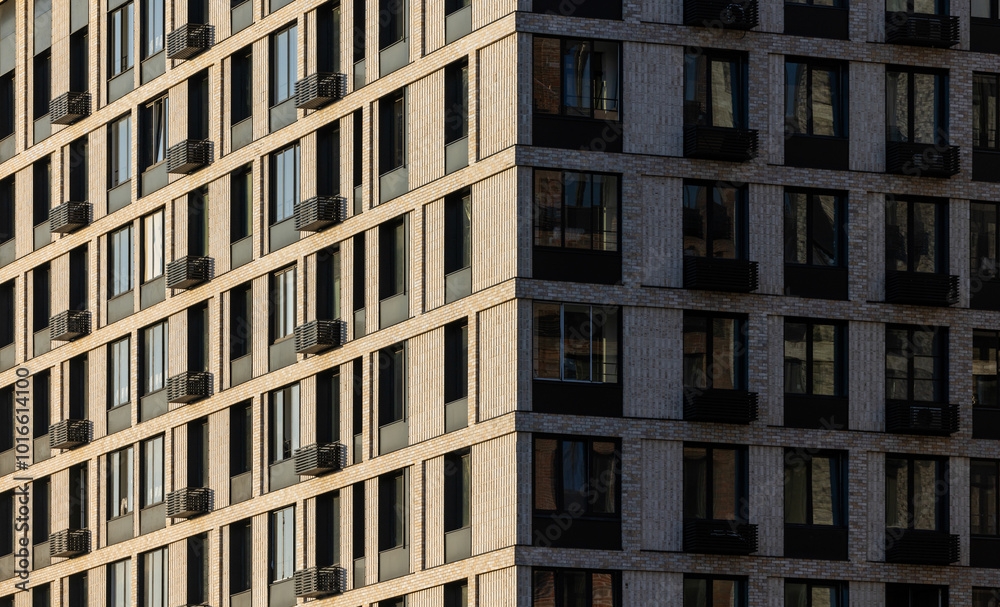 A contemporary building with a patterned facade features multiple windows reflecting the warm hues of a sunset. The structure highlights urban architecture and city life. A contemporary building with a patterned facade features multiple windows reflecting the warm hues of a sunset. The structure highlights urban architecture and city life.