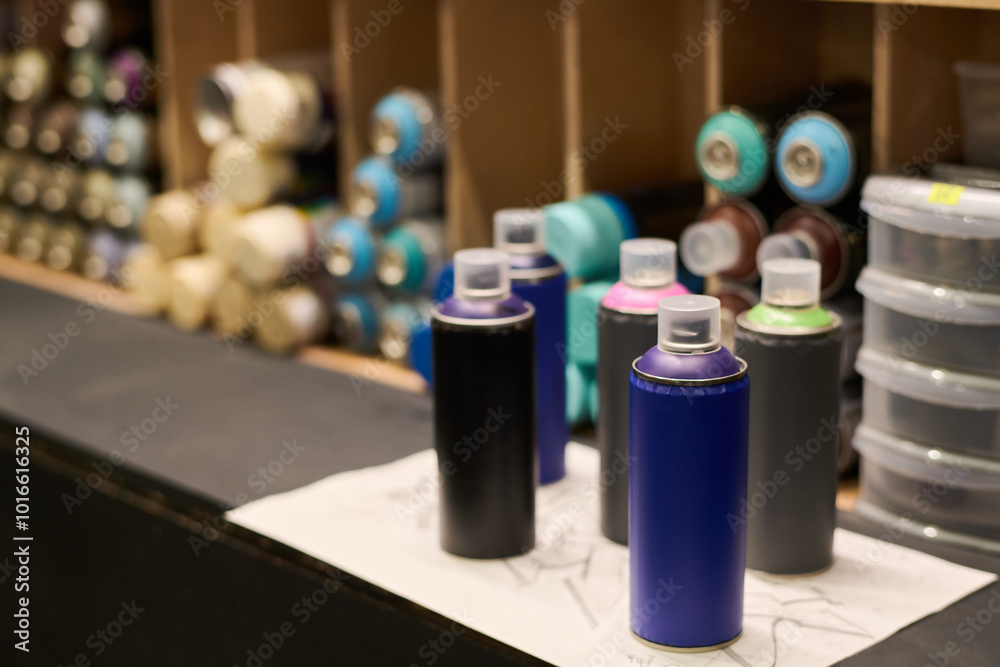 Group of unopened cans with graffiti paints of various colors standing on display in front of camera in art and craft shop Group of unopened cans with graffiti paints of various colors standing on display in front of camera in art and craft shop