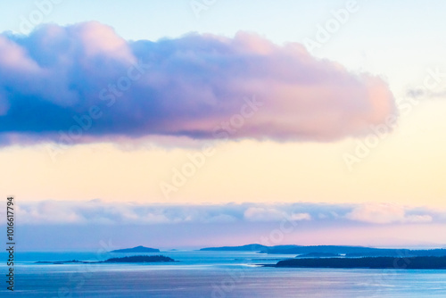 Obraz na płótnie Golden hues blend into the tranquil White Sea as the sun sets, casting a calming glow over distant islands and gentle clouds filling the sky. w salonie