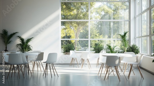 A modern break area in an office, featuring large windows that allow ample natural light to flood the space. The area is furnished with minimalist white tables and chairs