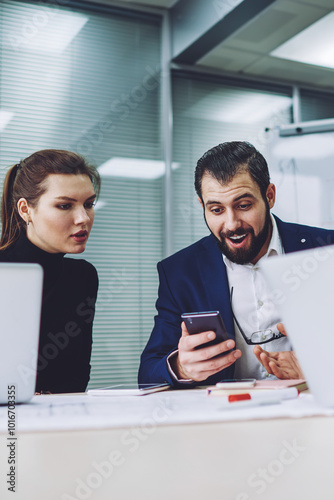 Happy male and female professional colleagues feeling excited and surpised from received sms message from boss with information about salary increase connected to office 4g wireless internet photo