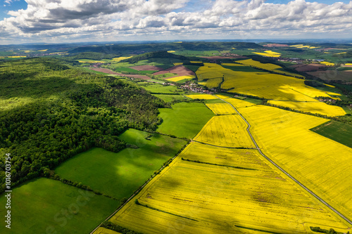 Obraz na płótnie Top view of rapeseed fields. Yellow rapeseed field with stripes and abstract landscape. Germany. w salonie