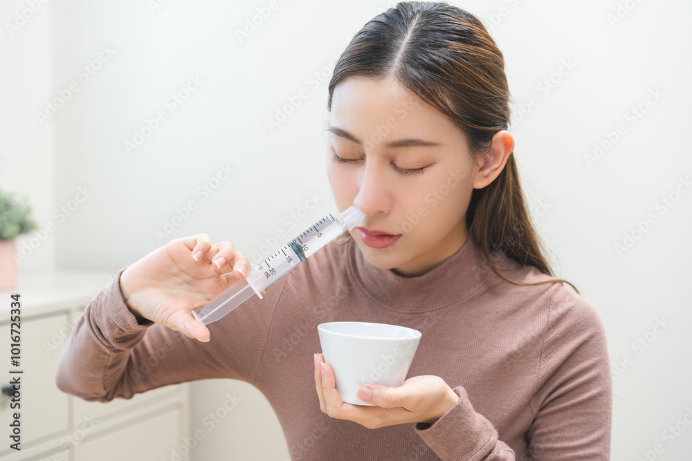 Health care wash nose, cleaning nose concept. Nasal irrigation asian young woman illness have a flu, fever, have a runny nose. Girl washes out nose with syringe and saline, infection, dust allergic. Health care wash nose, cleaning nose concept. Nasal irrigation asian young woman illness have a flu, fever, have a runny nose. Girl washes out nose with syringe and saline, infection, dust allergic.