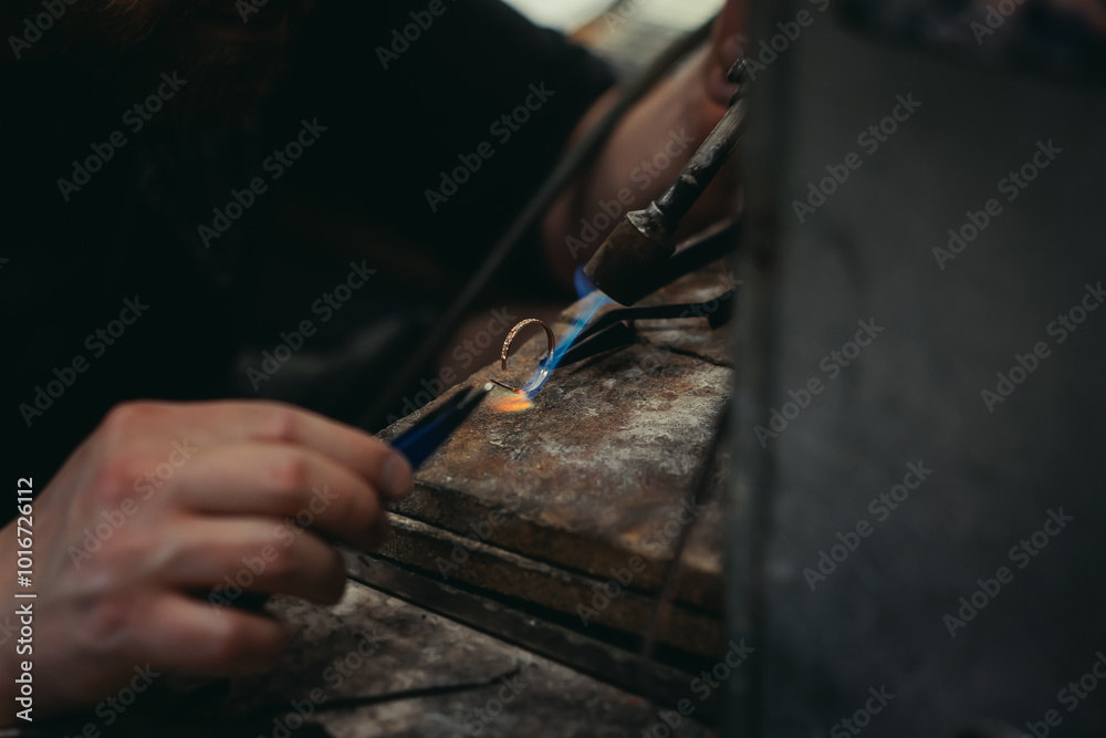 Obraz premium Close-up of a hand of a goldsmith who builds a precious jewel with valuable diamonds. To make the jewel it takes: precision, craftsmanship and patience. Concept of: gold, luxury.