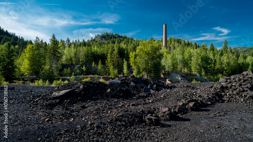 Forlorn and abandoned, all that remains of the once mighty Anaconda Copper Mine's smelter is a gargantuan slag heap and a solitary smoke stack.  Greenwood, British Columbia, Canada.