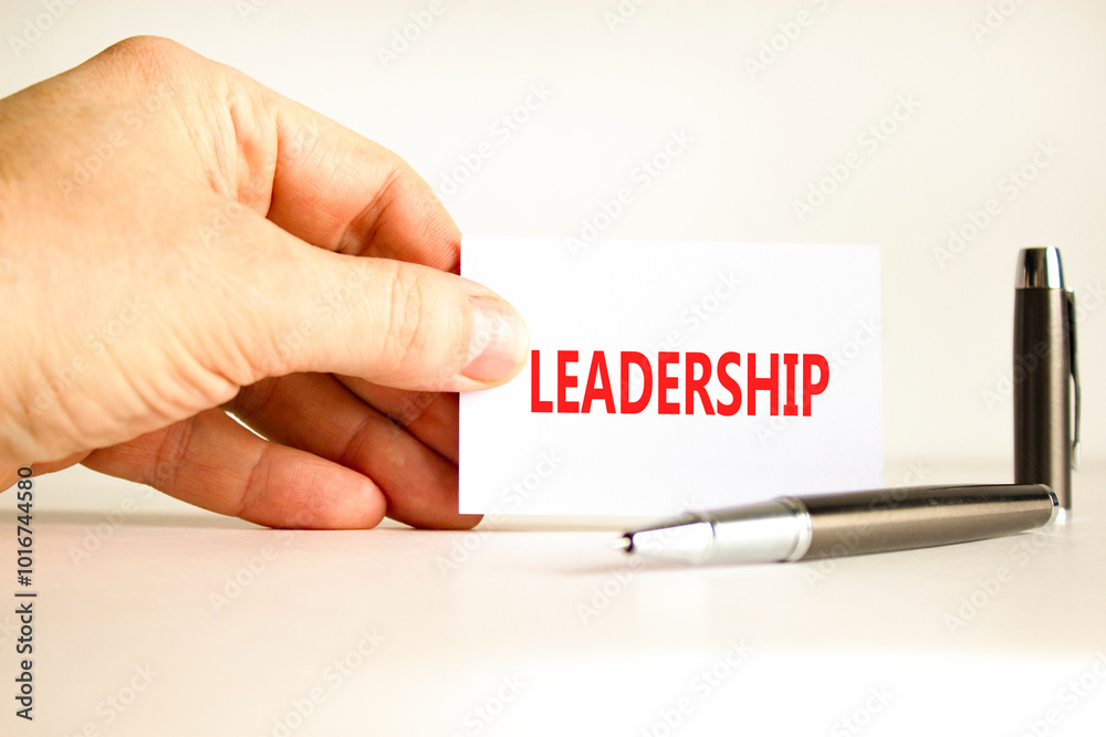 Leadership symbol. Concept word Leadership on beautiful white card. Beautiful wooden background. Businessman hand. Beautiful black pen. Business leadership concept. Copy space.