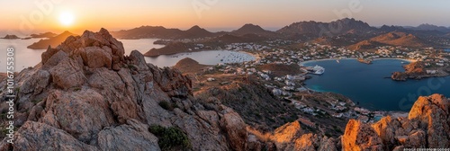  The sun sets over a mountain range, with a lake in the foreground and a town beyond it