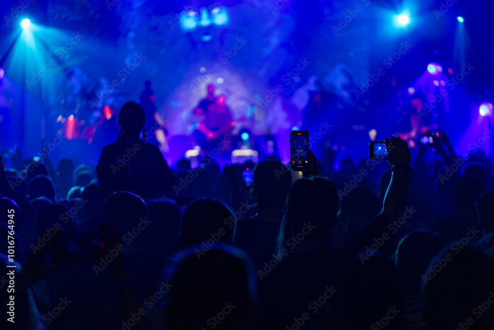 Hands holding phone and making photos on the concert. Hands holding phone and making photos on the concert.