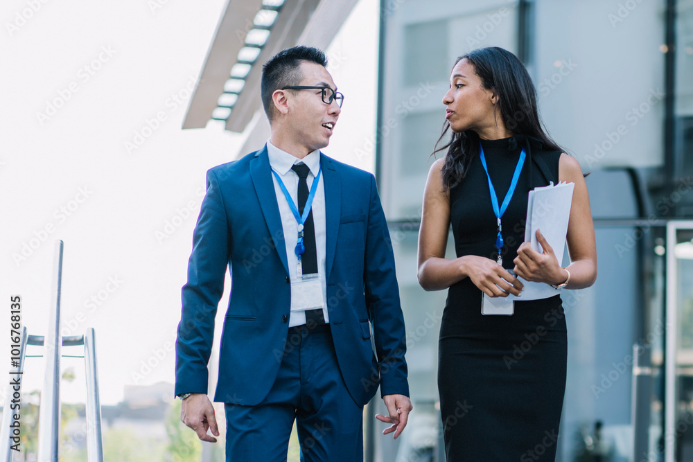 Fototapeta premium Stylish business people walking on street and talking