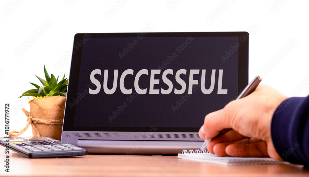 Successful symbol. Concept word Successful on beautiful black tablet. Beautiful wooden table white background. Businessman hand with pen. Business successful concept. Copy space. Successful symbol. Concept word Successful on beautiful black tablet. Beautiful wooden table white background. Businessman hand with pen. Business successful concept. Copy space.