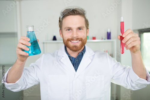 happy male scientist holding a flask and a test-tube