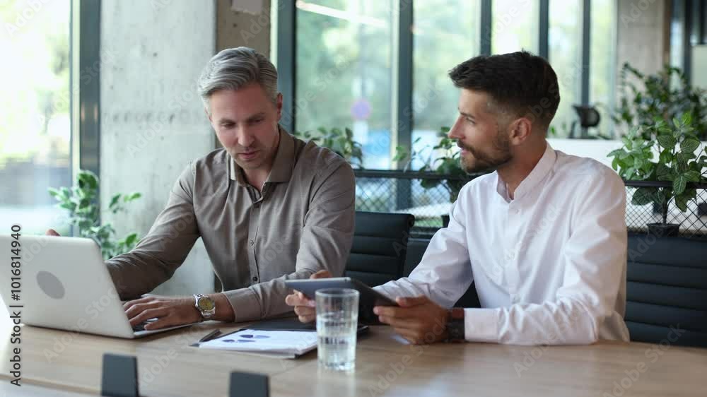 Two business men talking to each other discussing their business proposal. Two business men talking to each other discussing their business proposal.