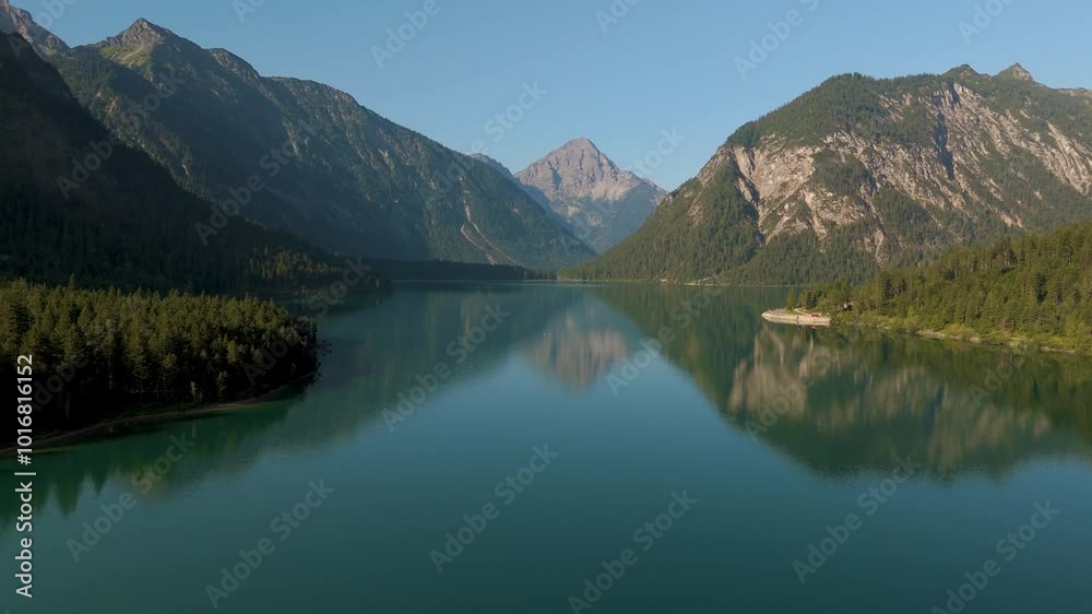 Pristine lake reflecting towering peaks, as gentle waves create mesmerizing patterns. Nature showcases its beauty in a vivid display of colors and calmness. Plansee Austria Pristine lake reflecting towering peaks, as gentle waves create mesmerizing patterns. Nature showcases its beauty in a vivid display of colors and calmness. Plansee Austria