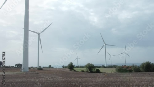 A field with several wind turbines in the background