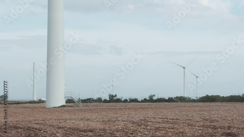 A wind farm with three wind turbines in the background