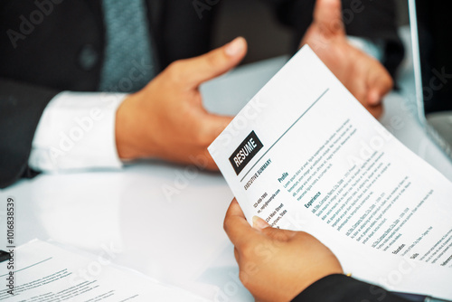 Human resources department manager reads CV resume document of an employee candidate at interview room. Job application, recruit and labor hiring concept. uds photo