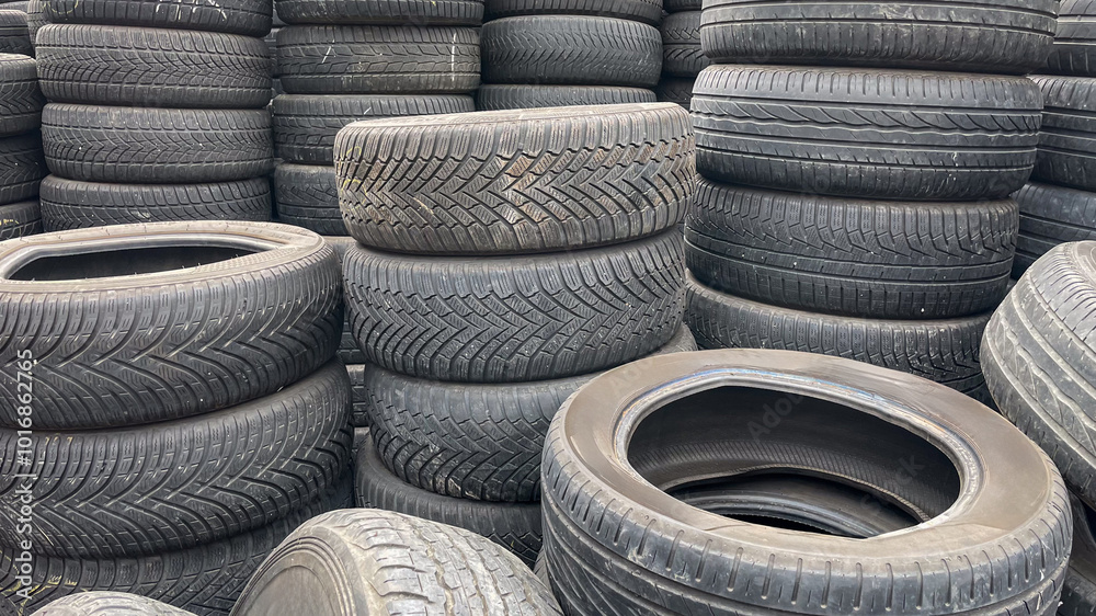 Stacks of old tires in a recycling center highlight environmental waste management issues and sustainable practices Stacks of old tires in a recycling center highlight environmental waste management issues and sustainable practices