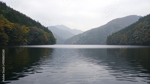 Tranquil lake surrounded by mountains and autumn foliage on a cloudy day