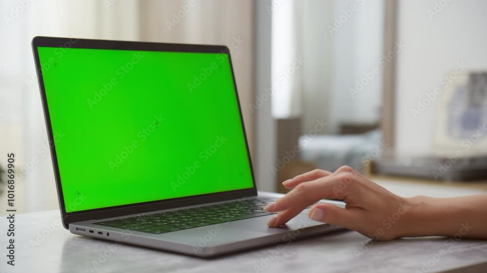 Hand Operating Laptop with Green Screen in a Home Environment Hand Operating Laptop with Green Screen in a Home Environment