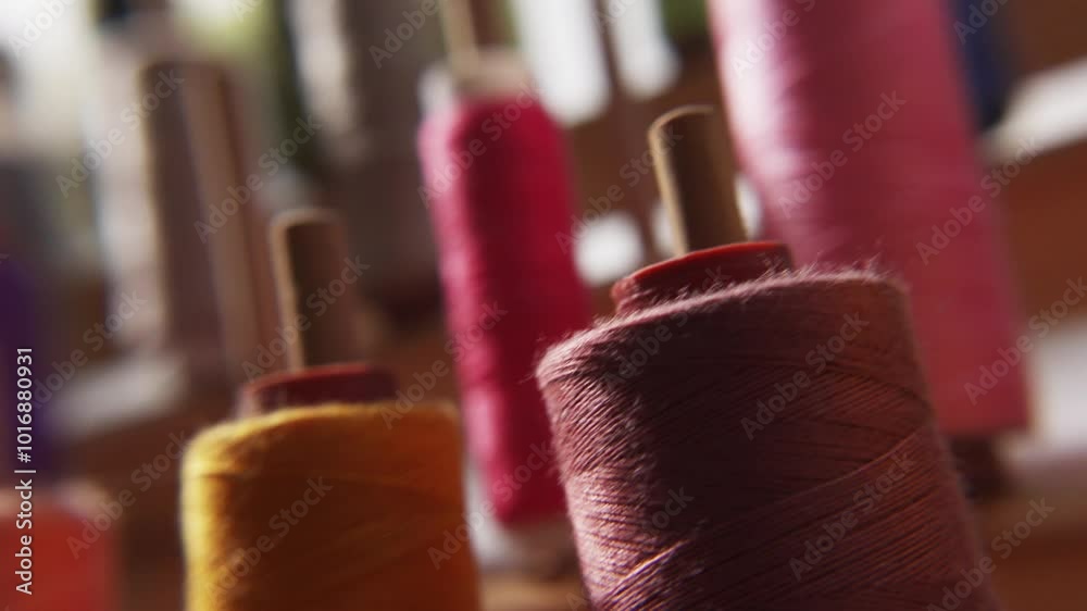 Different color threads hang on wall in sewing atelier