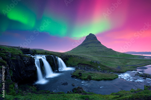 Incredible icelandic landscape with Kirkjufellsfoss waterfall under incredible sky with Northern lights. Kirkjufell volkano mountain and Polar lights in Iceland. Aurora borealis