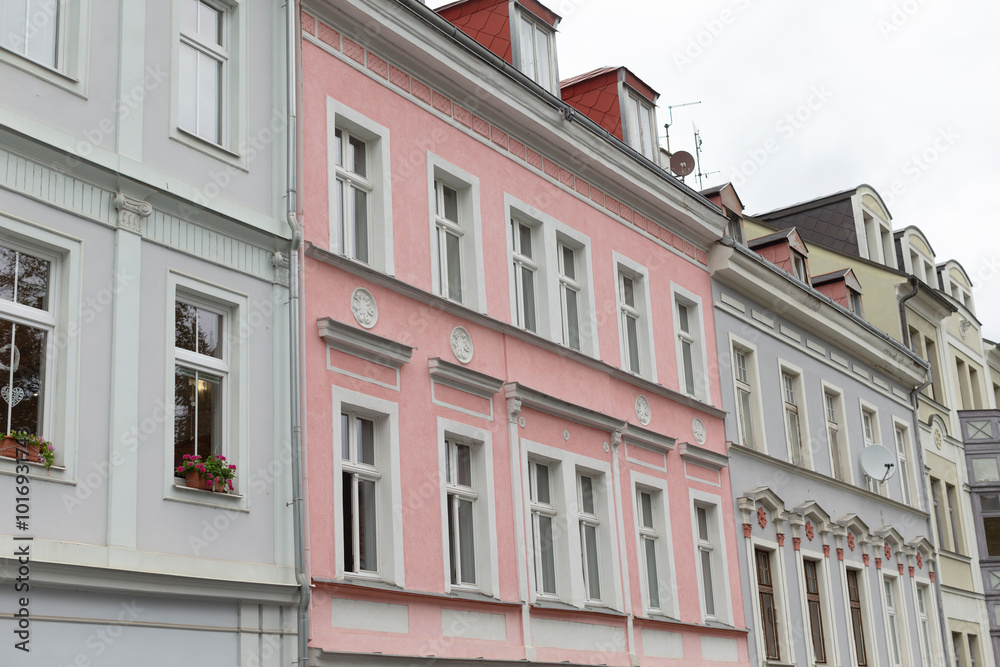 Obraz premium There is a long row of buildings, and prominently situated in the middle of this row is a striking pink building