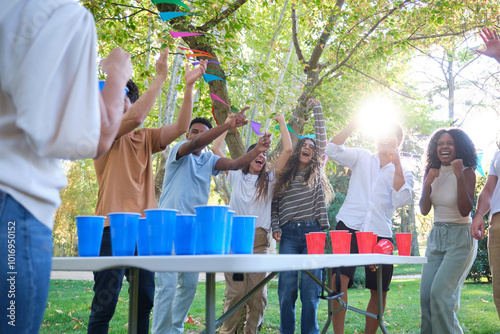 Obraz na płótnie Group of friends is having a party in the park and celebrating winning a beer pong game w salonie