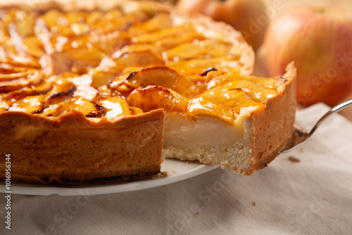 Cutting a slice of homemade traditional apple pie with pastry cream filling