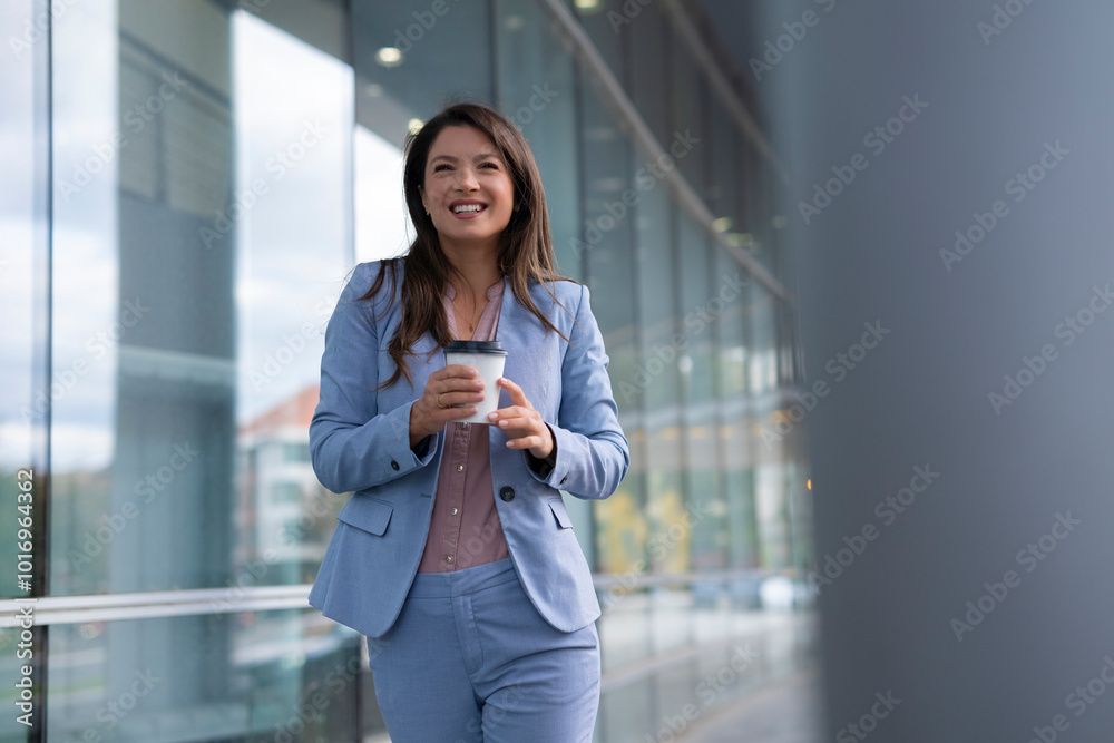 Happy businesswoman walking outdoor and holding cup of coffee Happy businesswoman walking outdoor and holding cup of coffee
