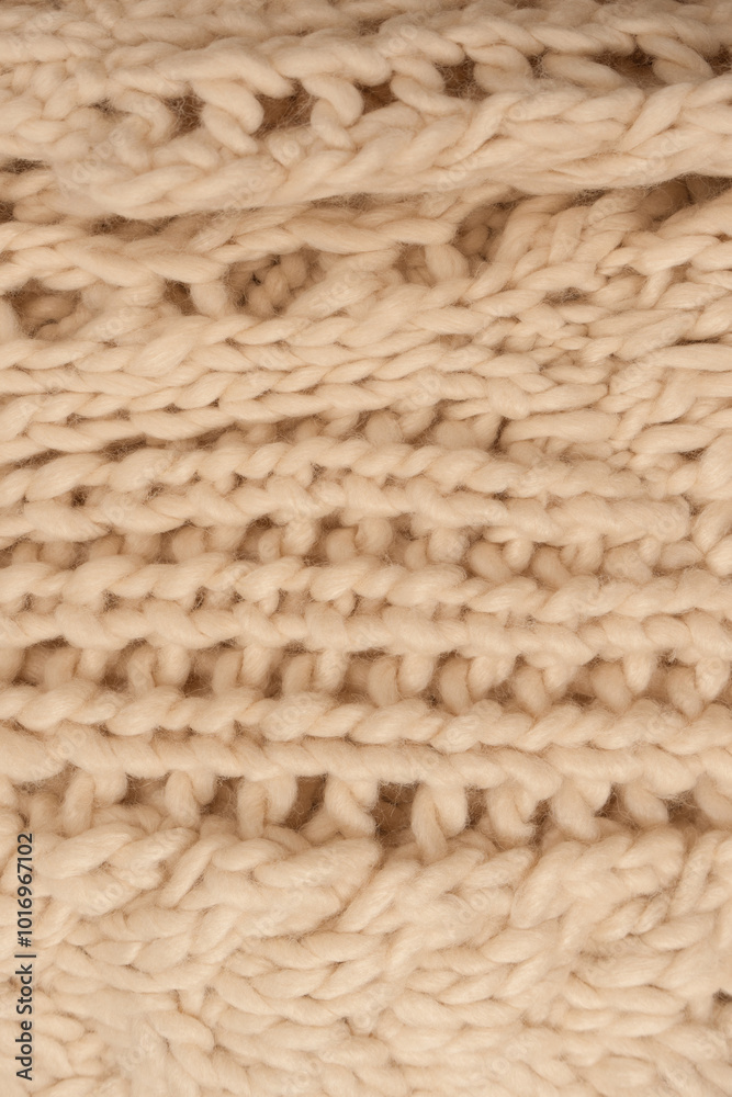 A fragment of beige knitted fabric, knitted from white sheep wool. A fragment of beige knitted fabric, knitted from white sheep wool.