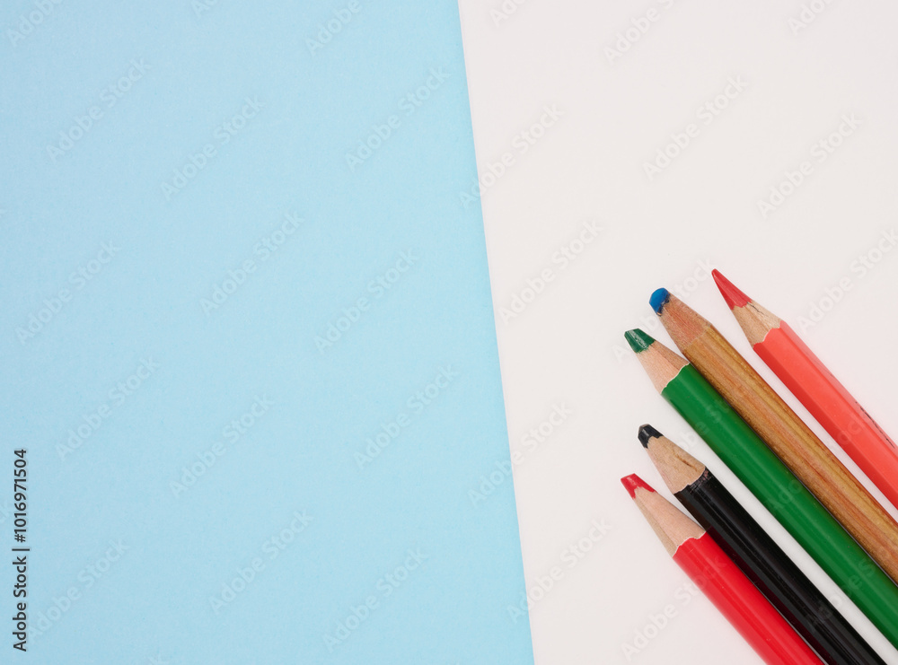 Fototapeta premium Multicolored wooden pencils on a blue background, top view