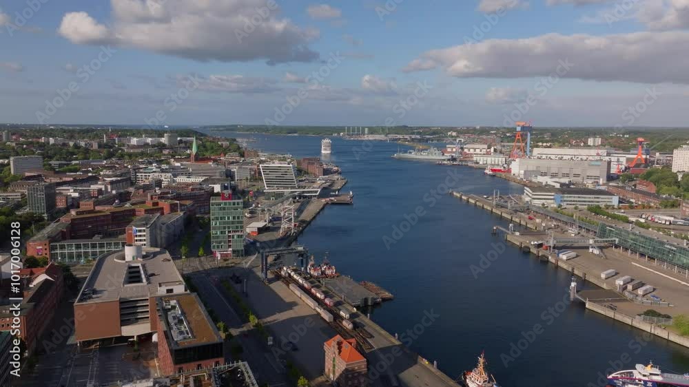 Cruise ship is entering the harbor of Kiel in Germany. The ship is sailing on the Kiel fjord passing industrial buildings and shipyards Cruise ship is entering the harbor of Kiel in Germany. The ship is sailing on the Kiel fjord passing industrial buildings and shipyards