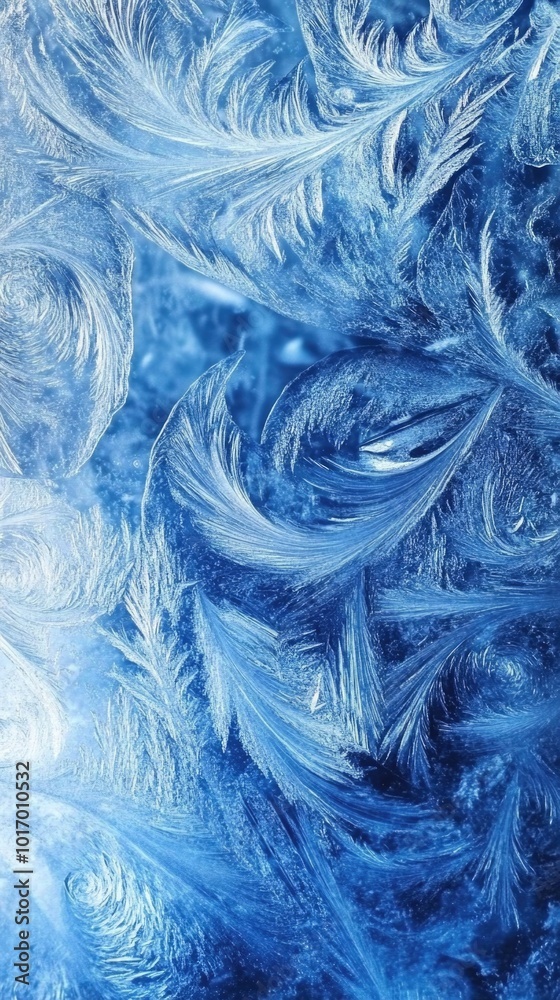 Obraz premium Intricate frozen windowpane featuring swirling frost patterns in cool blue tones
