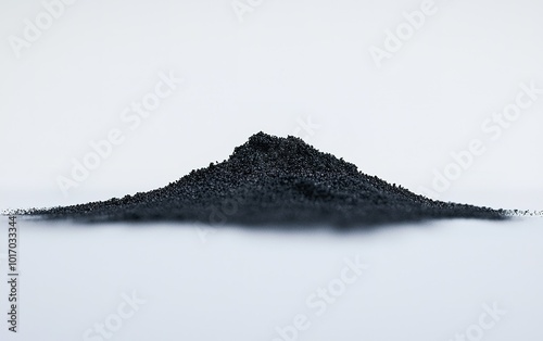 Black powdered substance arranged in a small mound on a flat surface with a plain background