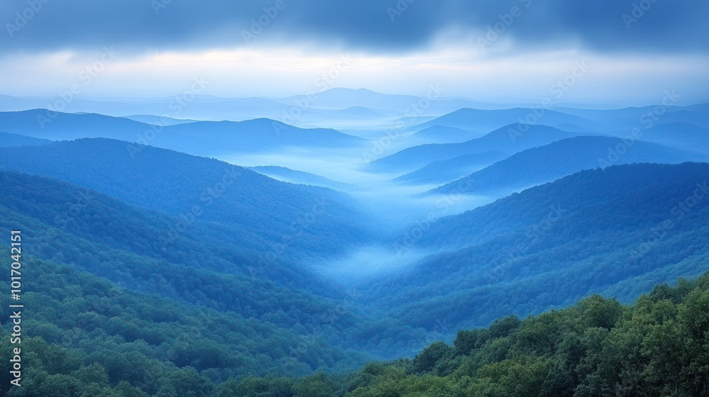 Fototapeta premium A peaceful morning unfolds as mist weaves through the blue-hued mountain valleys