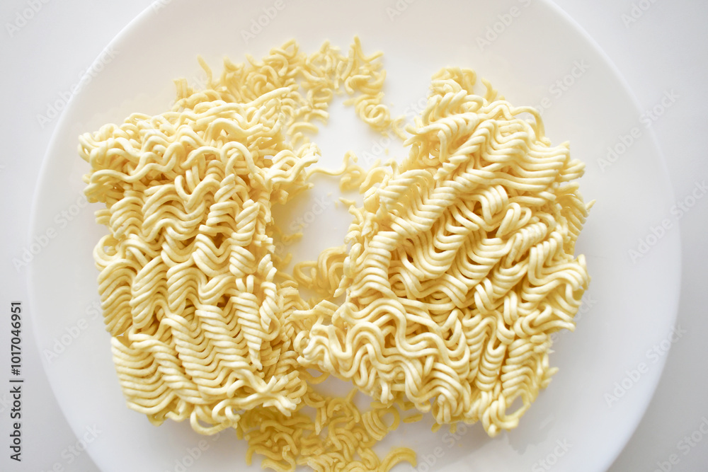 Uncooked instant noodles on a white plate. 