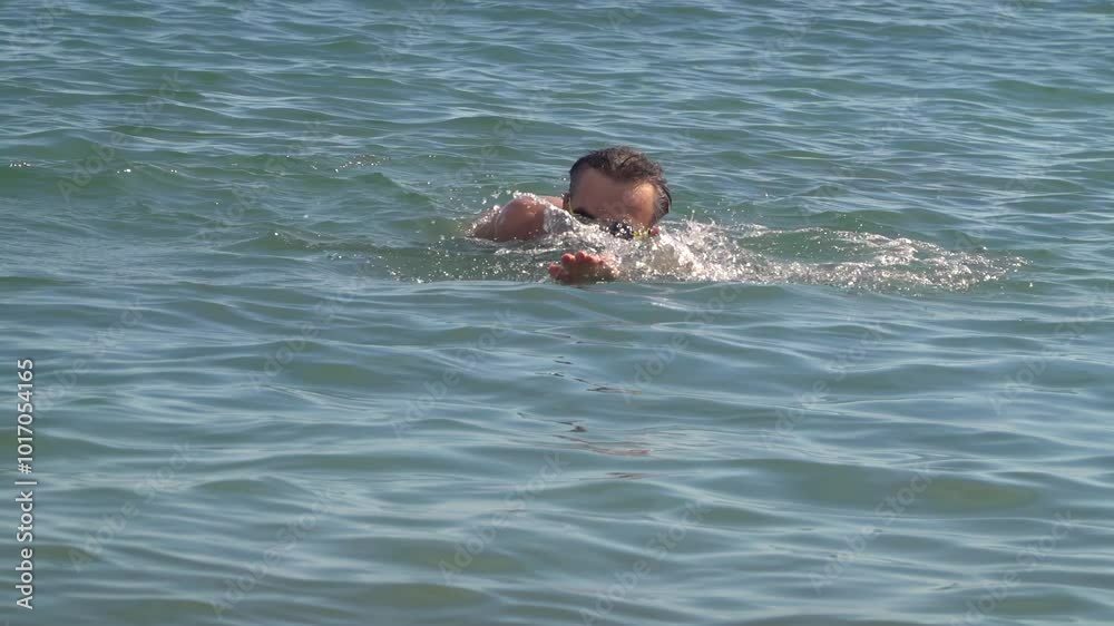 Man swimming in the sea on a sunny day Man swimming in the sea on a sunny day