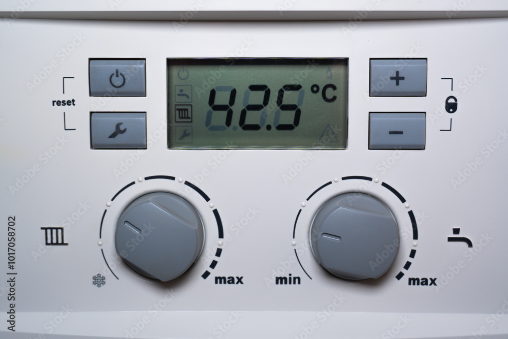 Close-up of a combi gas boiler control panel. A detailed image of the boiler's control panel featuring a digital display, buttons, and switches. Close-up of a combi gas boiler control panel. A detailed image of the boiler's control panel featuring a digital display, buttons, and switches.