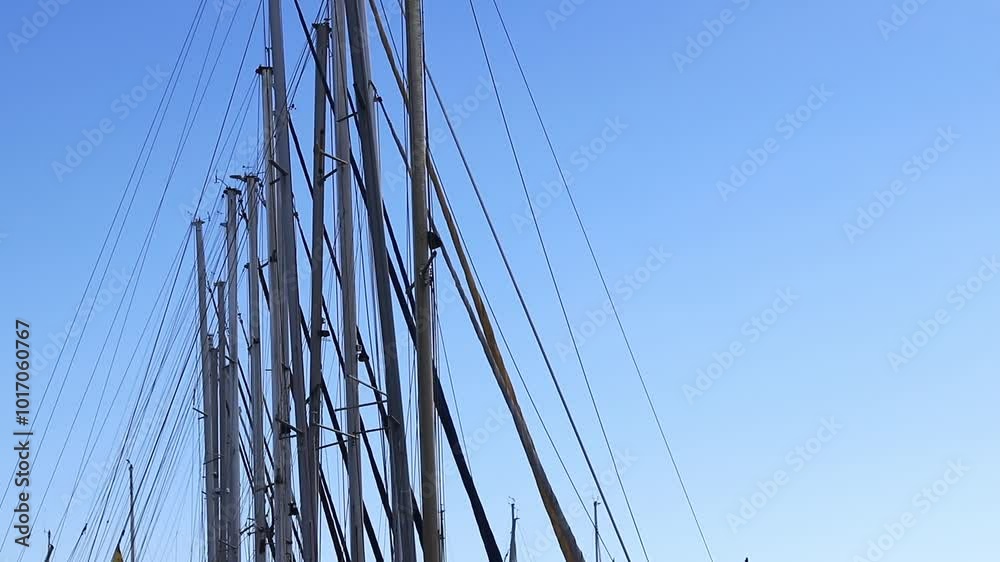 Masts of small yachts against the blue sky. Many yacht masts gently sway against the bright sky. Sports and recreation Masts of small yachts against the blue sky. Many yacht masts gently sway against the bright sky. Sports and recreation