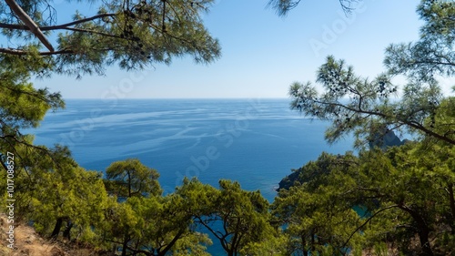 Turkish Mediterranean coastline as seen from the Lycian Way in Antalya, Turkey with a blue sea, lush green forests, and rugged rocky shores, attracting tourists every summer. photo