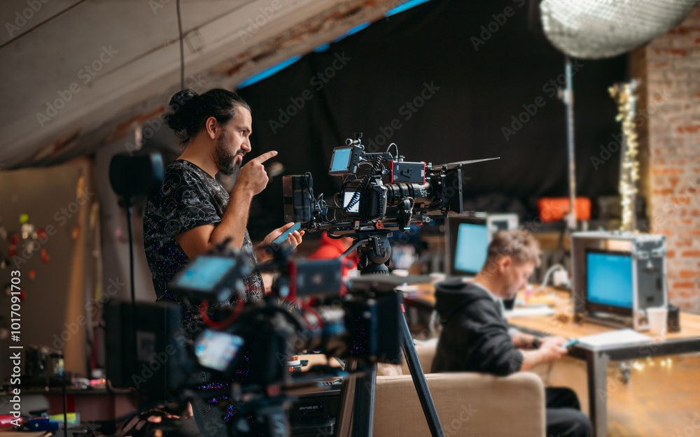 Director of photography with a camera in his hands on the set. Filming process indoors, studio Director of photography with a camera in his hands on the set. Filming process indoors, studio