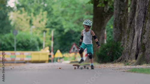 Wallpaper Mural Young boy standing on the skateboard, preparing to start his ride on the pathway. He adjusts his stance and concentrates on getting ready for an active session of skateboarding Torontodigital.ca
